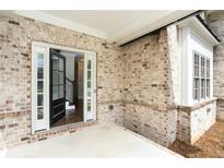 Inviting front entrance featuring a black front door flanked by sidelight windows with a brick exterior at 1300 Winfair Ne Ln, Brookhaven, GA 30329