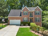 Charming two-story brick home with a well-maintained lawn, attached garage, and a basketball hoop at 858 Red Rock Ct, Suwanee, GA 30024