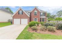 Charming two-story brick home with a well-manicured lawn and attached two-car garage at 330 Kentwood Springs Dr, Hampton, GA 30228