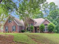 Charming brick home with well-manicured lawn, mature trees, and inviting front entrance at 1585 Lake Dow Rd, Mcdonough, GA 30252