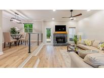 Bright living space with hardwood floors, fireplace, and an open floor plan to a dining area at 2012 Variations Ne Dr, Atlanta, GA 30329