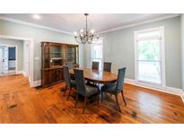 Traditional dining room featuring hardwood floors, a chandelier, a dark wood hutch, and two windows at 5780 Punkintown Rd, Douglasville, GA 30135