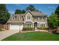 Charming two-story home with a well-manicured lawn, stone pathway, and neutral exterior at 230 Bristol Stone Ct, Johns Creek, GA 30005
