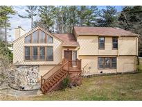Charming two-story home with wood siding, a prominent chimney, and a welcoming wooden staircase to the front door at 3032 Ross Rd, Snellville, GA 30039