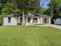 Charming renovated home with fresh white paint, mature landscaping, and inviting front porch at 4002 Lindsey Dr, Decatur, GA 30035