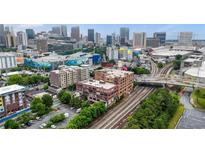 Stunning aerial view of the building with an expansive city skyline, vibrant art murals, and rail lines at 434 Marietta St Nw # 401, Atlanta, GA 30313