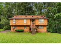 Two-story home with wood siding, lawn, and mature trees at 1822 Oriole Trl, Lithia Springs, GA 30122