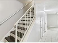 Bright staircase features painted white walls, white banister, and contrasting dark stained stairs at 6429 Woodstone Way, Morrow, GA 30260