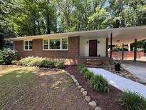 Charming brick home with well-maintained lawn, complemented by a carport and cozy front entrance at 224 Sourwood Dr, Marietta, GA 30062
