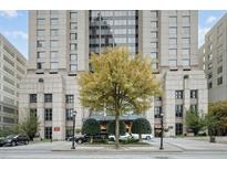 Elegant exterior view of a luxury building with well-manicured landscaping, a large tree, and street access at 75 14Th St Ne # 4140, Atlanta, GA 30309