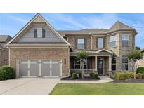 Inviting two-story home with manicured lawn, stone accents, and attached two car garage at 4815 Edgemoore Trce, Cumming, GA 30040