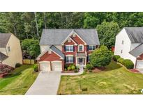 Charming brick home with a two-car garage, lush lawn, and well-manicured landscaping at 5312 Tormeal Trce, Suwanee, GA 30024
