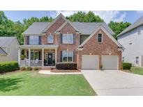 Charming two-story brick home with a well-manicured lawn and a welcoming front porch at 3930 Suwanee Bend Dr, Suwanee, GA 30024