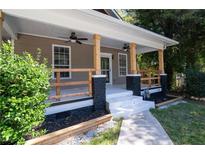 Inviting front porch with ceiling fans, painted steps, and natural wood railing detail on a home with neutral siding at 1712 Evans Sw Dr, Atlanta, GA 30310