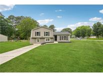 Charming home featuring a well-maintained lawn, complemented by fresh exterior paint and dark shutters at 1915 North Rd, Snellville, GA 30078