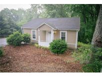 Charming cottage-style home featuring a cozy front porch and a well-maintained, tree-lined landscape at 329 Kelly Mill Rd, Cumming, GA 30040