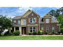 Beautiful two-story brick home with a manicured lawn and mature landscaping at 321 Champions Dr, Fairburn, GA 30213