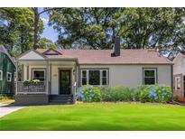Charming single-story home featuring a cozy front porch, well-manicured lawn, and lush landscaping at 139 Sisson Ne Ave, Atlanta, GA 30317