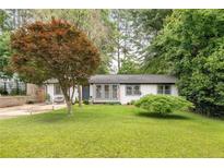 Charming single-story home featuring a well-maintained lawn, lush landscaping, and a welcoming entrance at 2572 Beverly Hills Drive Dr, Chamblee, GA 30341