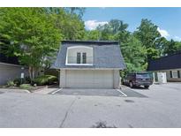 Charming townhome featuring a two-car garage and balcony overlooking the parking area at 5490 Chemin De Vie, Sandy Springs, GA 30342