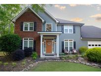 Charming two-story home featuring a well-maintained lawn, a combination brick and vinyl facade, and a welcoming front porch at 4130 Providnce Square, Alpharetta, GA 30009