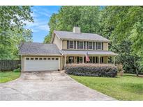Charming two-story home featuring a covered front porch, attached garage, and well-manicured landscaping at 12510 Georgia 36, Covington, GA 30014