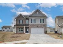 Charming two-story home with brick and siding, a two-car garage, and a well-manicured lawn in a friendly neighborhood at 408 Westmarch Cir, Loganville, GA 30052