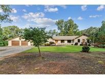 Charming ranch-style home featuring lush green lawn, mature trees, and a detached two-car garage at 980 Casteel Rd, Powder Springs, GA 30127