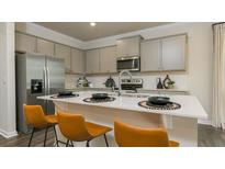 Modern kitchen featuring stainless steel appliances, gray cabinetry, and a quartz island with seating at 3050 Yellowhammer Dr, Marietta, GA 30064