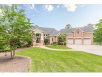 Stately brick home with a manicured lawn and a three-car garage, complete with lush landscaping and an inviting entrance at 3718 Lake Vis, Douglasville, GA 30135