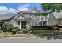 Charming two-story home with stone accents, landscaped front yard, and inviting covered porch at 595 Stonepark Ln, Suwanee, GA 30024