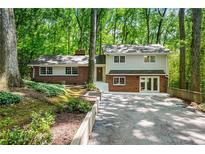 Charming two-story home with brick facade and a well-manicured front yard surrounded by lush greenery at 893 Vistavia Cir, Decatur, GA 30033