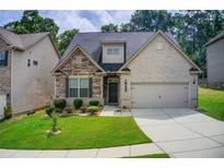 Charming home featuring stone and brick exterior with a well-manicured lawn and attached two-car garage at 555 Lance View Ln, Lawrenceville, GA 30045
