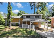 Charming two-story house with a covered car port and damaged windows at 2641 Clifton Springs Rd, Decatur, GA 30034