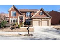 Charming two-story brick home with a two-car garage and landscaped front yard on a sunny day at 3505 Belridge Ln, Smyrna, GA 30080