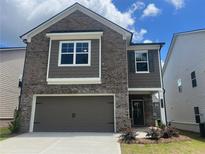Charming two-story home with a brick facade, two-car garage and welcoming front entrance at 4554 Eastbrook Pl, Snellville, GA 30039