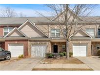 Charming brick townhome featuring an attached garage and well-maintained landscaping at 2555 Flat Shoals Road Rd # 1104, College Park, GA 30349
