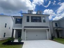 Charming two-story home featuring a finished garage and neutral gray painted brick at 4524 Eastbrook Pl, Snellville, GA 30039