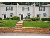 Charming townhouse with brick facade, well-maintained lawn, and black shutters on light colored brick at 1771 Defoor Nw Ave # D, Atlanta, GA 30318