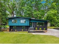 Stunning renovated home with an elegant blue and black exterior and well-manicured lawn at 2873 Bob White Sw Dr, Atlanta, GA 30311