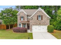 Charming two-story brick home featuring a well-manicured lawn and attached two-car garage at 830 Nottingham Se Dr, Smyrna, GA 30082