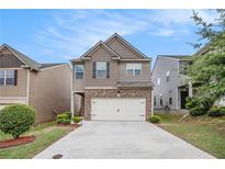 Charming two-story home featuring a brick facade and a two-car garage, complemented by a well-maintained front yard at 5152 Rapahoe Trl, Atlanta, GA 30349