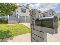 Charming two-story home features a well-manicured lawn, gray stairs and a two-car garage at 7262 Sandpiper Way, Riverdale, GA 30274