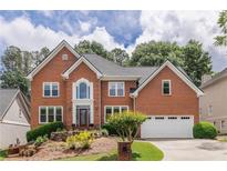 Beautiful two-story brick home featuring a landscaped front yard and attached two-car garage at 4960 Haydens Walk Dr, Johns Creek, GA 30022