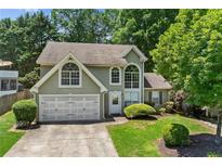 Charming home with a manicured lawn, two-car garage, and mature trees offering curb appeal at 850 Long Branch Cir, Sugar Hill, GA 30518