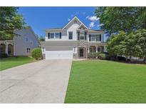 Charming two-story home with stone accents, well-manicured lawn, and an attached two-car garage at 955 Mill Creek Ave, Canton, GA 30115