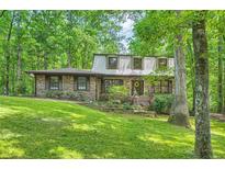 Charming two-story brick home nestled in a wooded setting with a beautifully landscaped front yard at 1580 Smyrna Sw Rd, Conyers, GA 30094