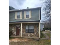 Two-story townhouse featuring stone accents, green siding, shuttered windows, and a welcoming front door at 3500 Ten Oaks Ct, Powder Springs, GA 30127