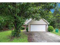 Charming one-story home featuring a well-manicured lawn and attached two-car garage at 4732 Browns Mill Ferry Rd, Lithonia, GA 30038