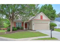 Charming single Gathering home with a well-manicured lawn, two-car garage, and a welcoming front porch at 502 Helene Ct, Woodstock, GA 30188
